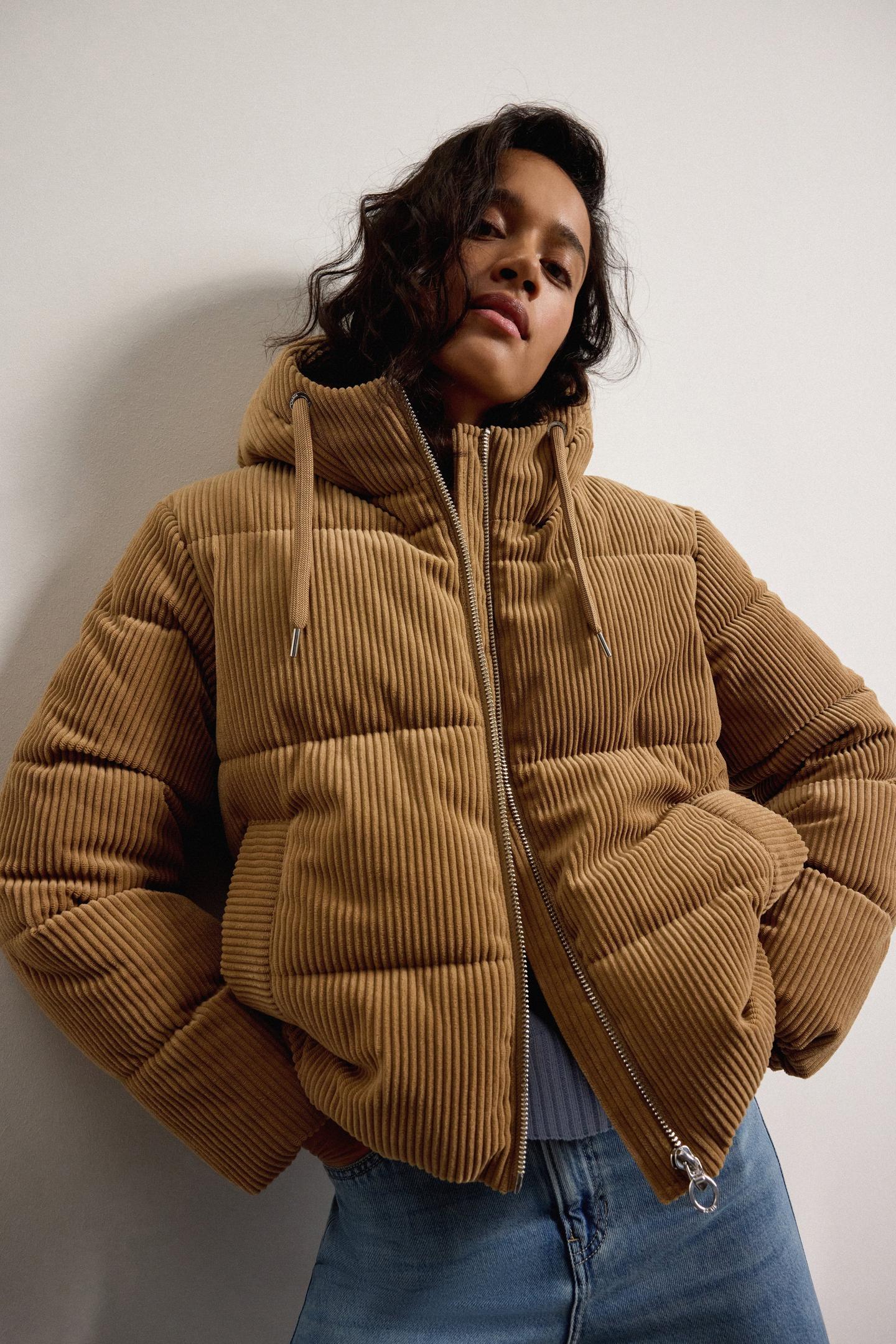 Frau mit offener, brauner Winterjacke